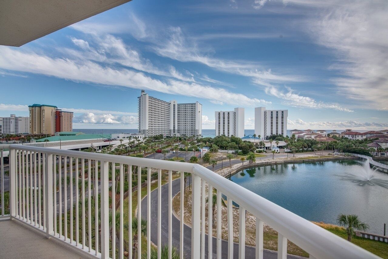 A high-rise hotel with a view of a lake, a fountain, and surrounding buildings.