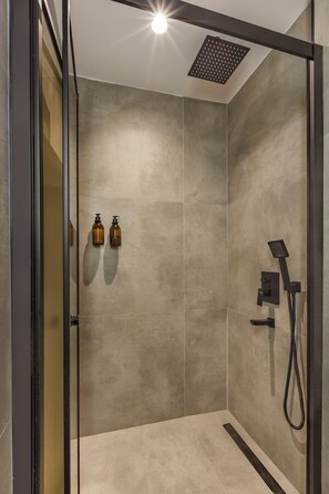 Superior driepersoonskamer | Badkamer | Een douche, een regendouche, designer toiletartikelen, een haardroger