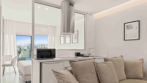 A modern kitchen with a built-in microwave, a stainless steel range hood, and a small countertop. -  Limassol Seaside Residences 06 (Limassol)