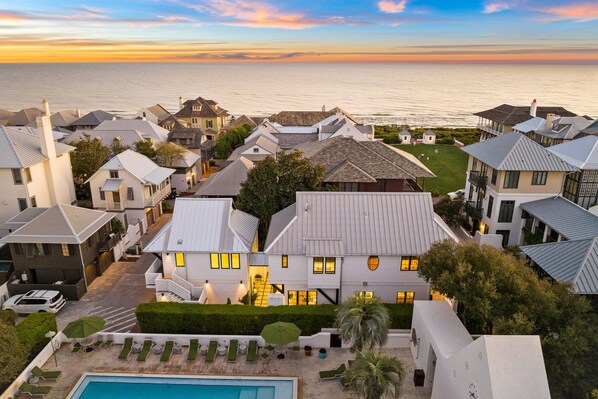 Una zona residencial costera con casas, una piscina y vistas al océano.