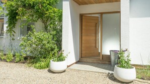 A modern building with a wooden door and a small porch area. - Morawel, St Dogmaels (Saint Dogmaels)