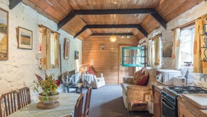 A cozy cabin interior with a dining area, a living room, and a kitchen. - Rhyd y Brown Cottage, Llys Y Fran (Clarbeston Road)