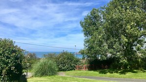 A grassy area with a paved path, trees, and a view of the sea. - Mount Pleasant, Newport (Newport)