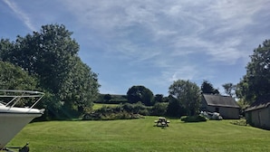 A grassy outdoor area with a picnic table and a boat docked on the left. - Mount Pleasant, Newport (Newport)