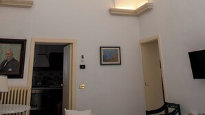 Una habitació amb un sostre alt i arquejat, una taula de dinar, una cadira i un quadre al mur.