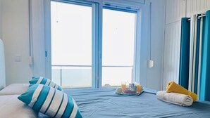A hotel room with a bed, pillows, a tray with breakfast items, and a view of the outside. - Roses - Los Sauces - Apart 3 rooms (Rosas / Roses)