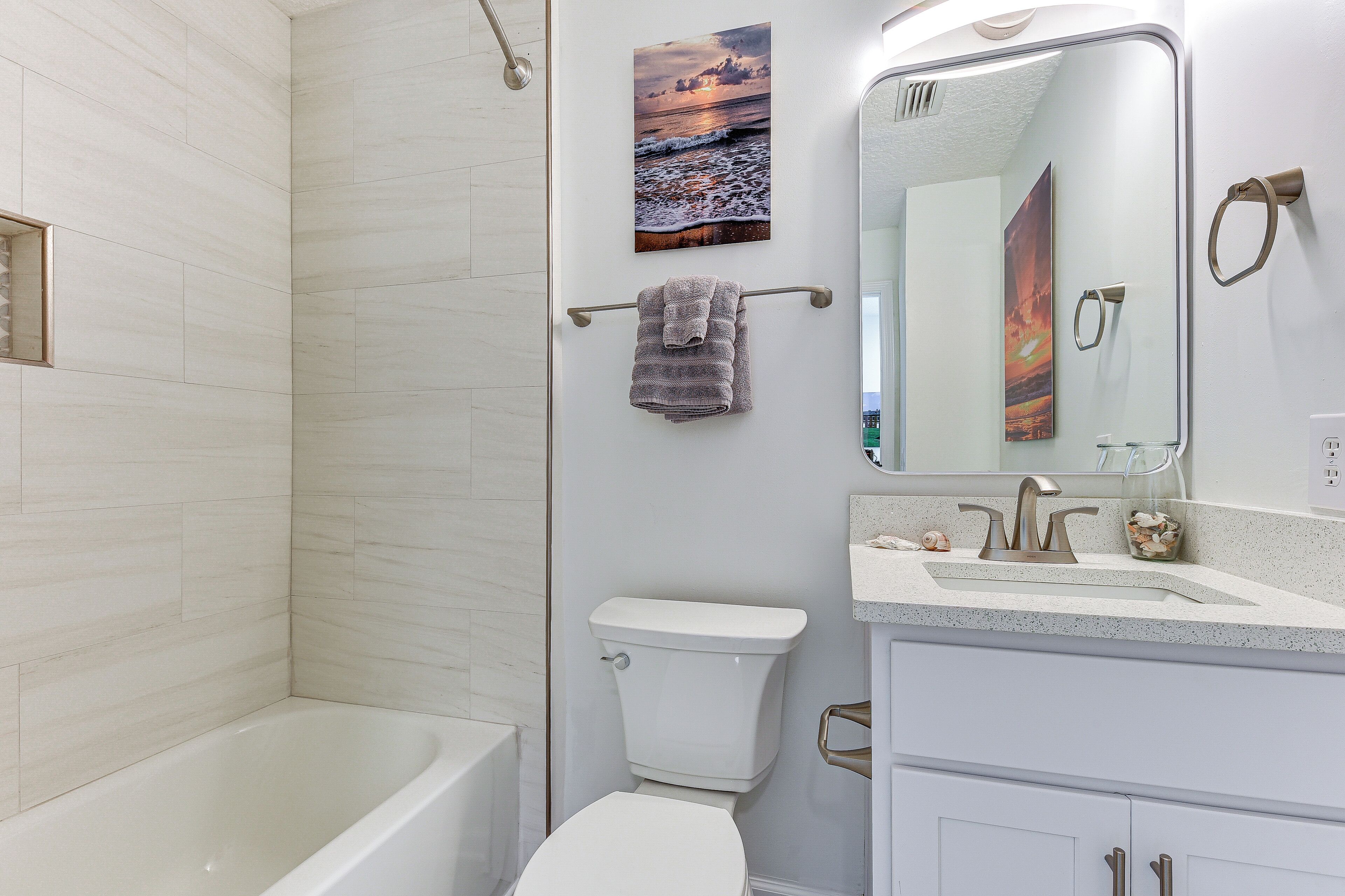 A modern bathroom with a bathtub, toilet, and sink.