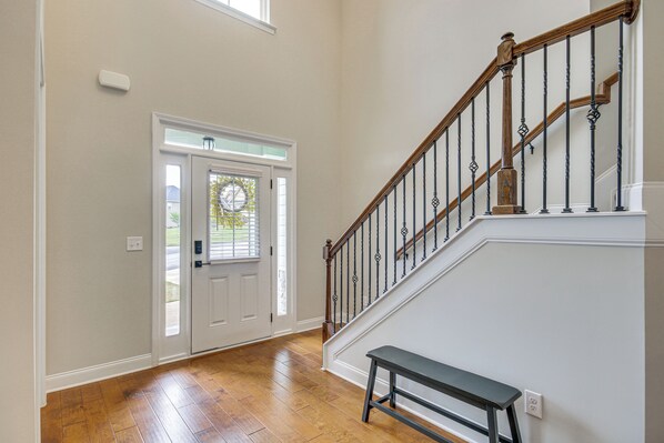 A hallway with a wooden staircase, a bench, and a door with a window. - Spacious Aiken Home ~ 8 Mi to Downtown! (Aiken)