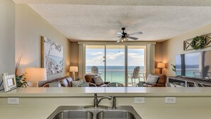 A modern kitchen with a large island, double sinks, and a view of the ocean. - Beachfront Panama City Beach Condo w/ Outdoor Pool (Panama City Beach)