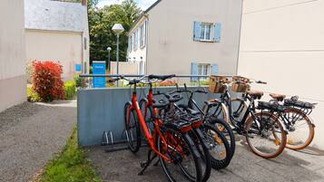 A row of bicycles parked in front of a building with a signboard.