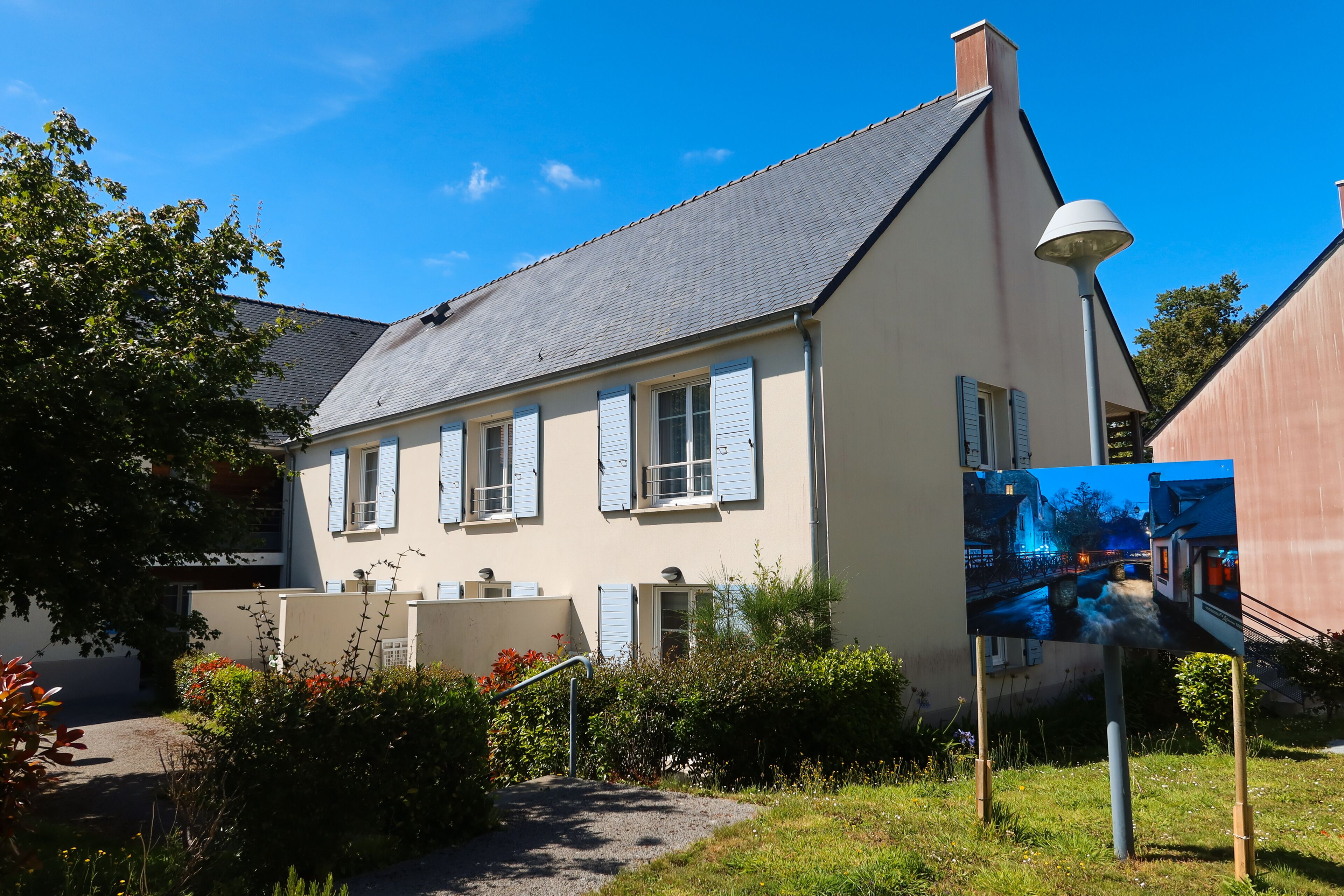 A two-story house with a sloped roof and a small front garden.