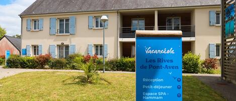 A hotel named Vacances de Pont-Aven with a sign listing amenities like reception, SPA, and form spaces.