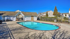 A residential swimming pool with a brick border, surrounded by houses and a fence. - Cozy Greensboro Townhome w/ Community Pool & Grill (Greensboro)
