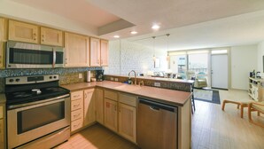 Une cuisine moderne avec des meubles en bois, des appareils en acier inoxydable et un grand îlot central.