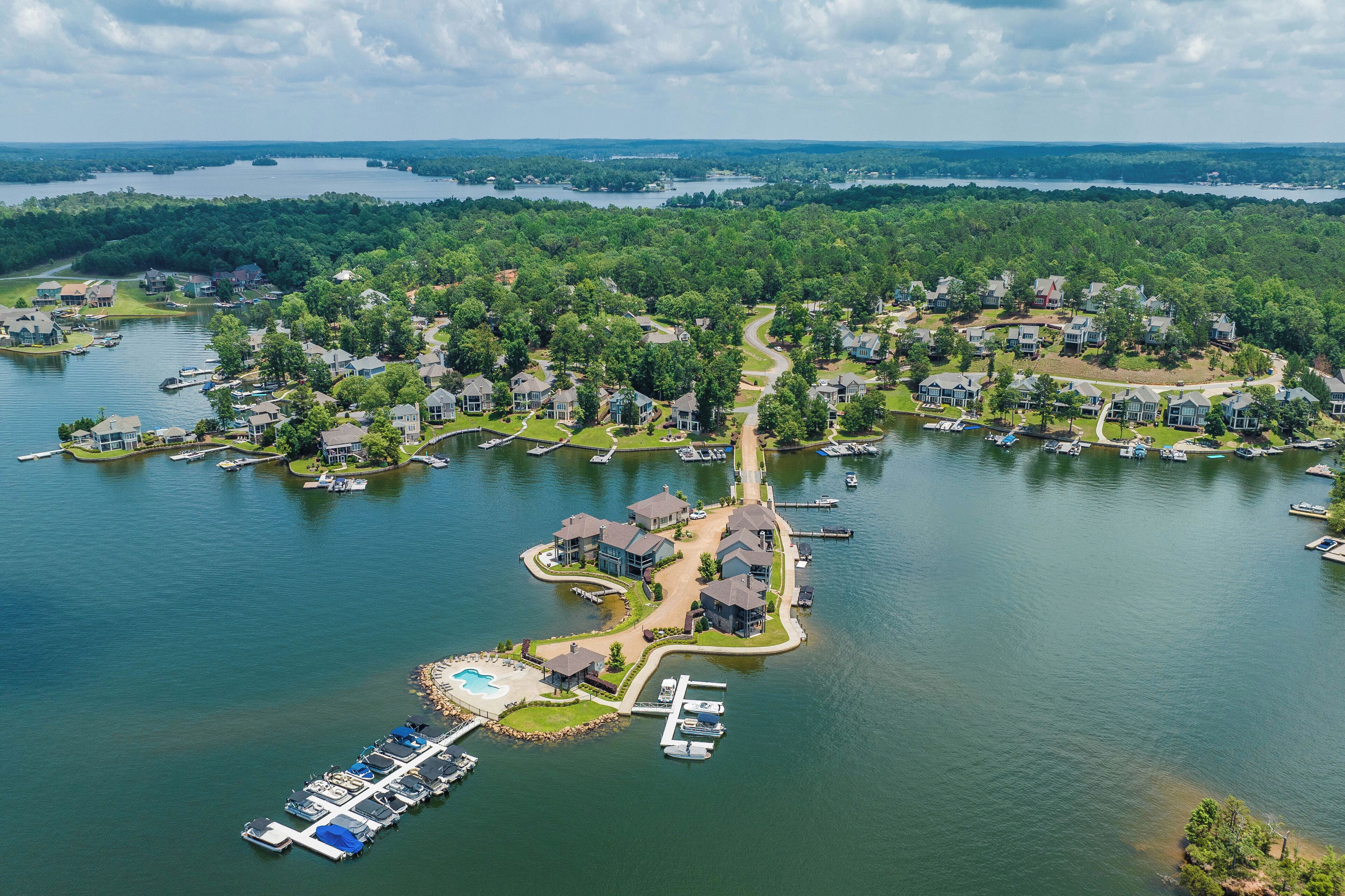 An aerial view of a lakeside community with residential houses, docks, and boats.