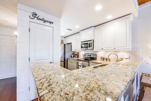 A modern kitchen with white cabinetry, granite countertops, and stainless steel appliances. - Balcony + Community Perks: Lake Martin Condo! (Dadeville)