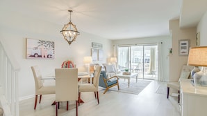 A spacious living room with a dining area, a chandelier, and a view to the outside. - Porch & Water Views: Getaway in Mallard Lakes (Selbyville)