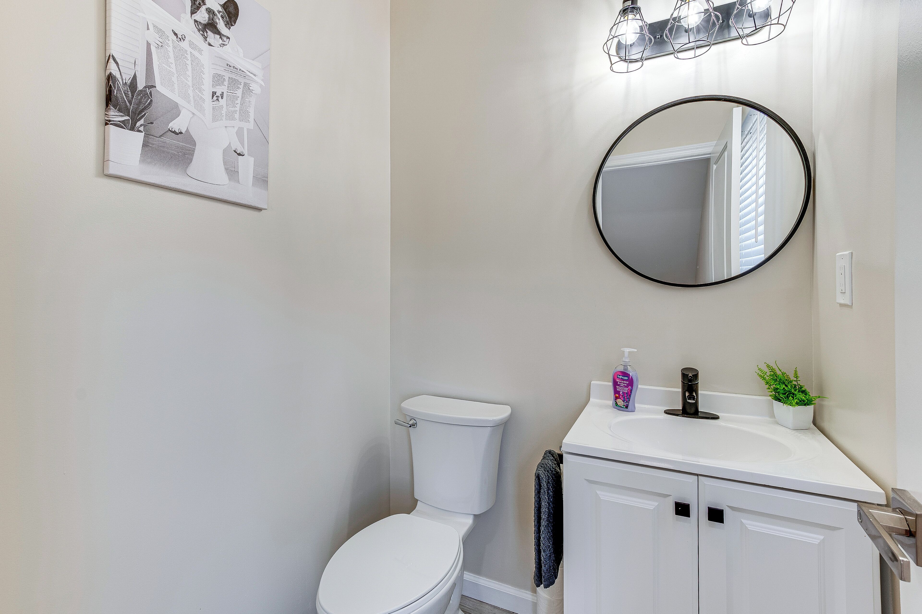 Une salle de bain moderne avec des toilettes, un lavabo et un miroir.
