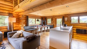 Ein Blockhaus-Interieur mit Essbereich, Sofa und Küche.