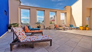 A rooftop patio with lounge chairs and potted plants. - Maison Rioma - Grande maison à 200m de la plage (Plounéour-Trez)