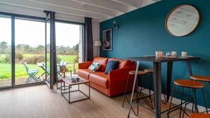 Una sala de estar moderna con un sofá rojo, una mesa de centro y un comedor con mesa y sillas.
