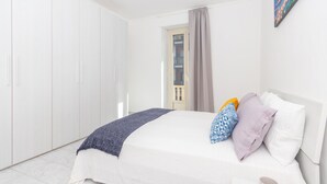 A bedroom with a bed, pillows, a blanket, a wardrobe, and a painting on the wall. - Casa Delia by Wonderful Italy (Turin)