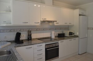 A modern kitchen with white cabinets, a granite countertop, a built-in oven, a microwave, and a coffee maker. - Beautiful Villa Sunflower with private pool and garden, nearby the beaches. (Xabia)