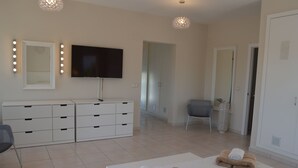A modern bedroom with a large bed, a TV, a wardrobe, and a chair. - Beautiful Villa Sunflower with private pool and garden, nearby the beaches. (Xabia)