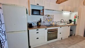 A kitchen with white cabinets, a microwave, a sink, and a stove.