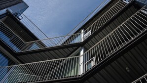 Un edificio a più livelli con un design architettonico moderno, caratterizzato da balconi con ringhiere in metallo e ampie finestre.