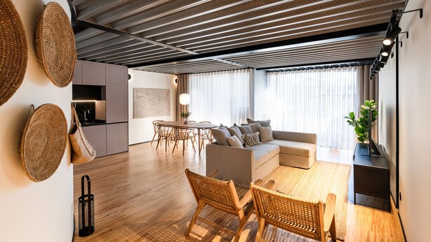 Una sala de estar moderna con un sofá, una mesa de comedor y sillas.