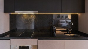 A modern kitchen with black cabinetry, a stainless steel sink, and a Bosch range hood. - Feel Porto Matosinhos City Flat III (Matosinhos)
