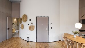 A modern interior with a curved wall, a wooden dining table, and a minimalist design. - Feel Porto Matosinhos City Flat III (Matosinhos)