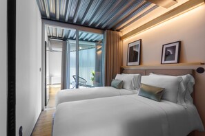 Una habitación de hotel moderna con dos camas, un ventanal grande y un techo de diseño único.