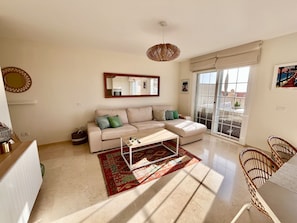 A living room with a sofa, coffee table, and a large window with a view. - Superbe Duplex Avec vue mer - Jacuzzi, Jardin & Terrasse Privés (Palm-Mar)