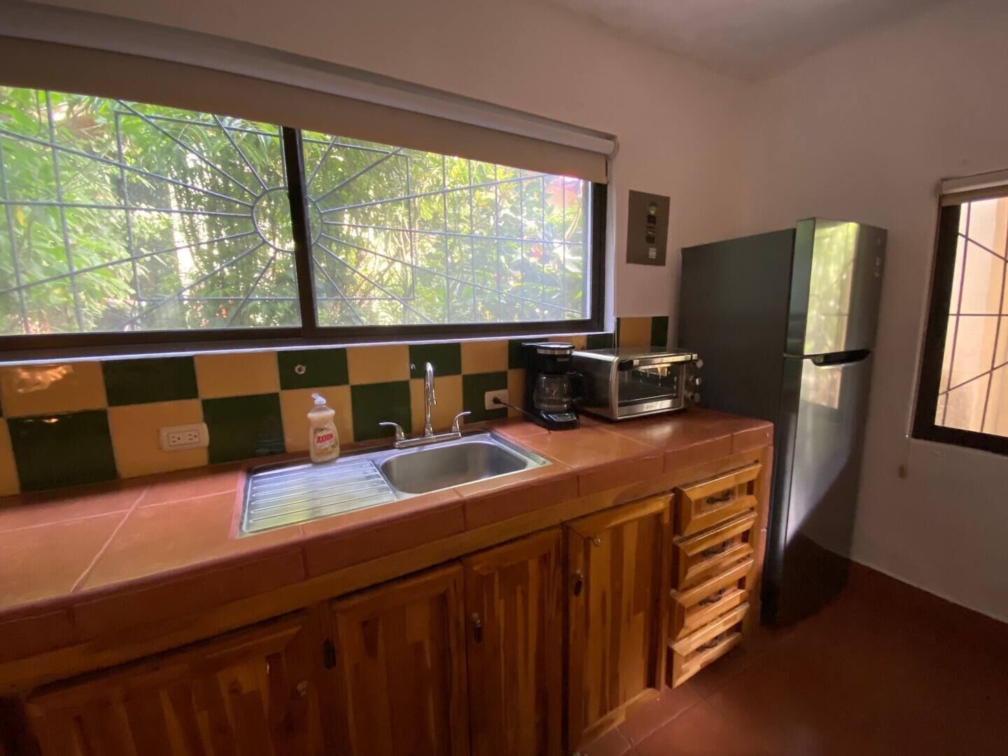 Eine Küche mit Fenster, Spüle, Toaster und Kühlschrank.