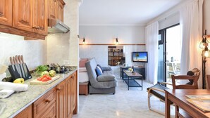 A modern kitchen with wooden cabinets, a granite countertop, and a dining area with a sofa and table.