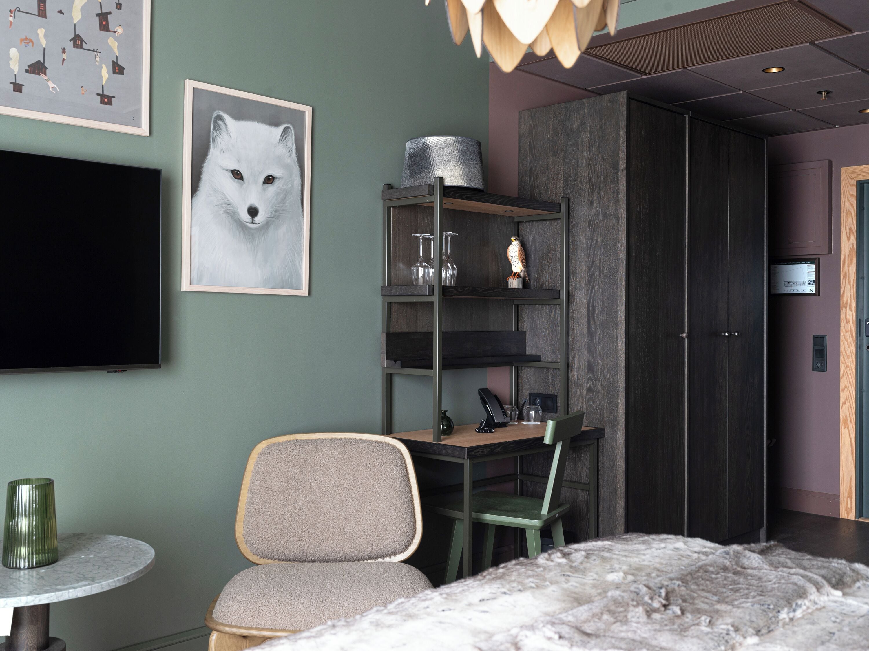 A modern bedroom with a bed, a desk, a chair, a TV, and a bookshelf.