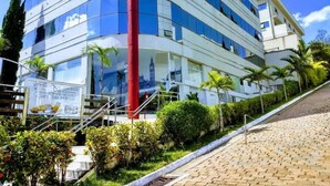 Un edificio moderno con fachada de vidrio, un pilar rojo y un cartel.
