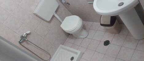 Un baño con inodoro, bidé, lavabo y ducha.