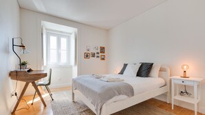 A bedroom with a bed, bedside table, lamp, chair, desk, and a window. - Charming Graça Apartment, Lisbon City Centre, TTL354a (Lisboa ciudad)