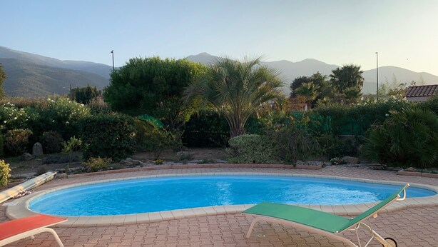 A swimming pool with a paved deck, surrounded by lush greenery and mountains in the background. - LA Rocanya Villa Classée 4 Avec Chambres Climatisées Piscine Privée Sécurisée (Laroque-des-Albères)