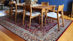 A dining area with a wooden table and chairs, a chandelier, and a blue accent wall. - Historic Craftsman 3 Bedroom Home in Uptown Butte (Butte)
