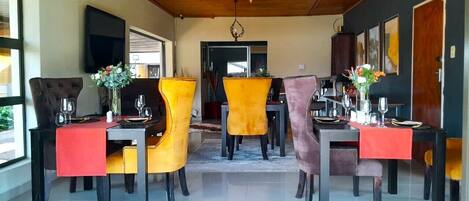 A dining area with a wooden ceiling and a view of the outdoors.