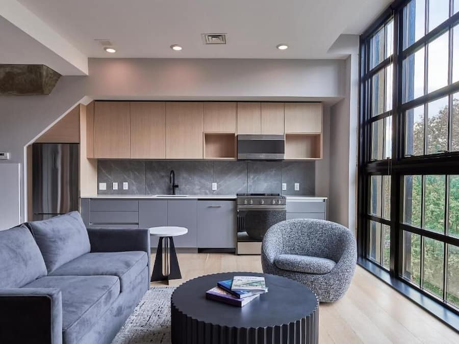 A modern kitchen with a built-in oven, microwave, and a large window.