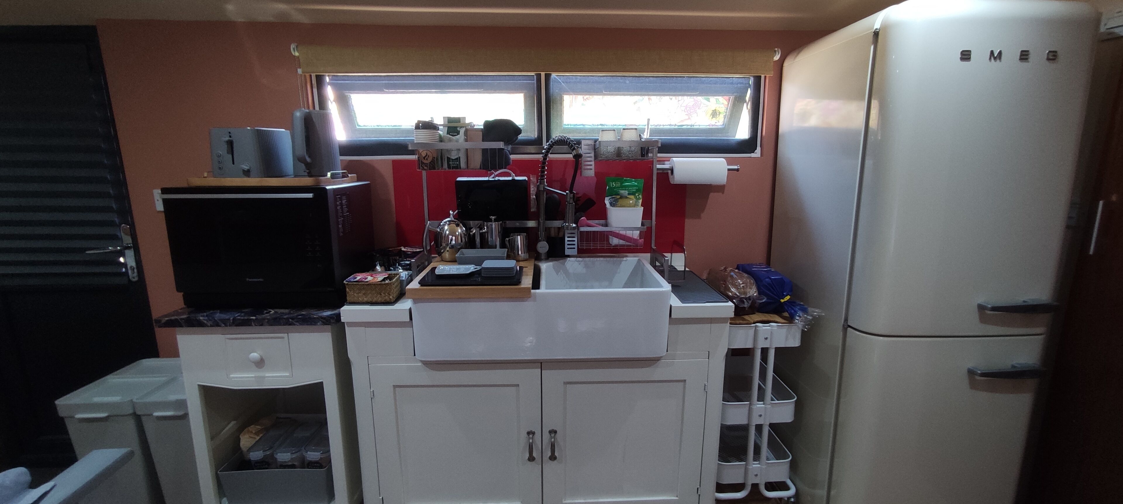 A compact kitchen with a microwave, sink, and refrigerator.