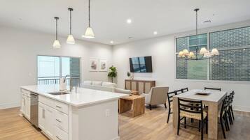 A modern kitchen with a central island, white cabinetry, and pendant lighting.