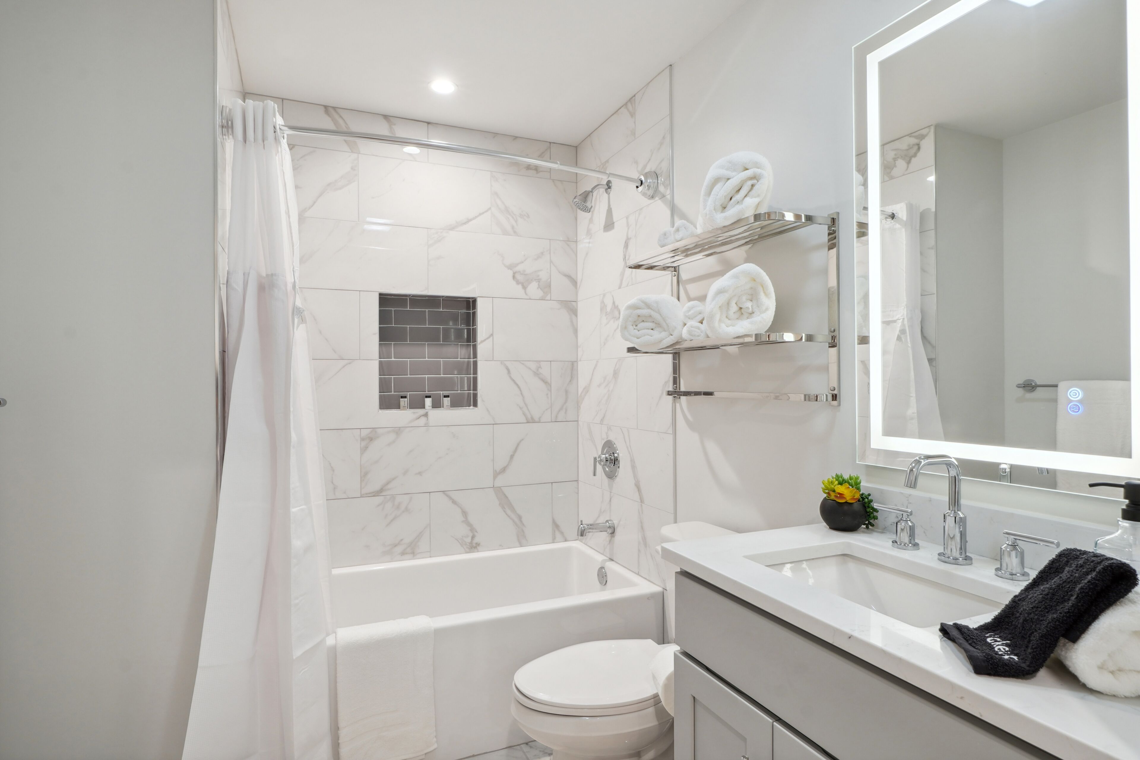 A modern bathroom with a bathtub, toilet, and sink.