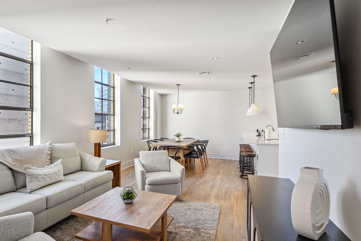 Un salon moderne avec un canapé, une table basse et un coin repas.