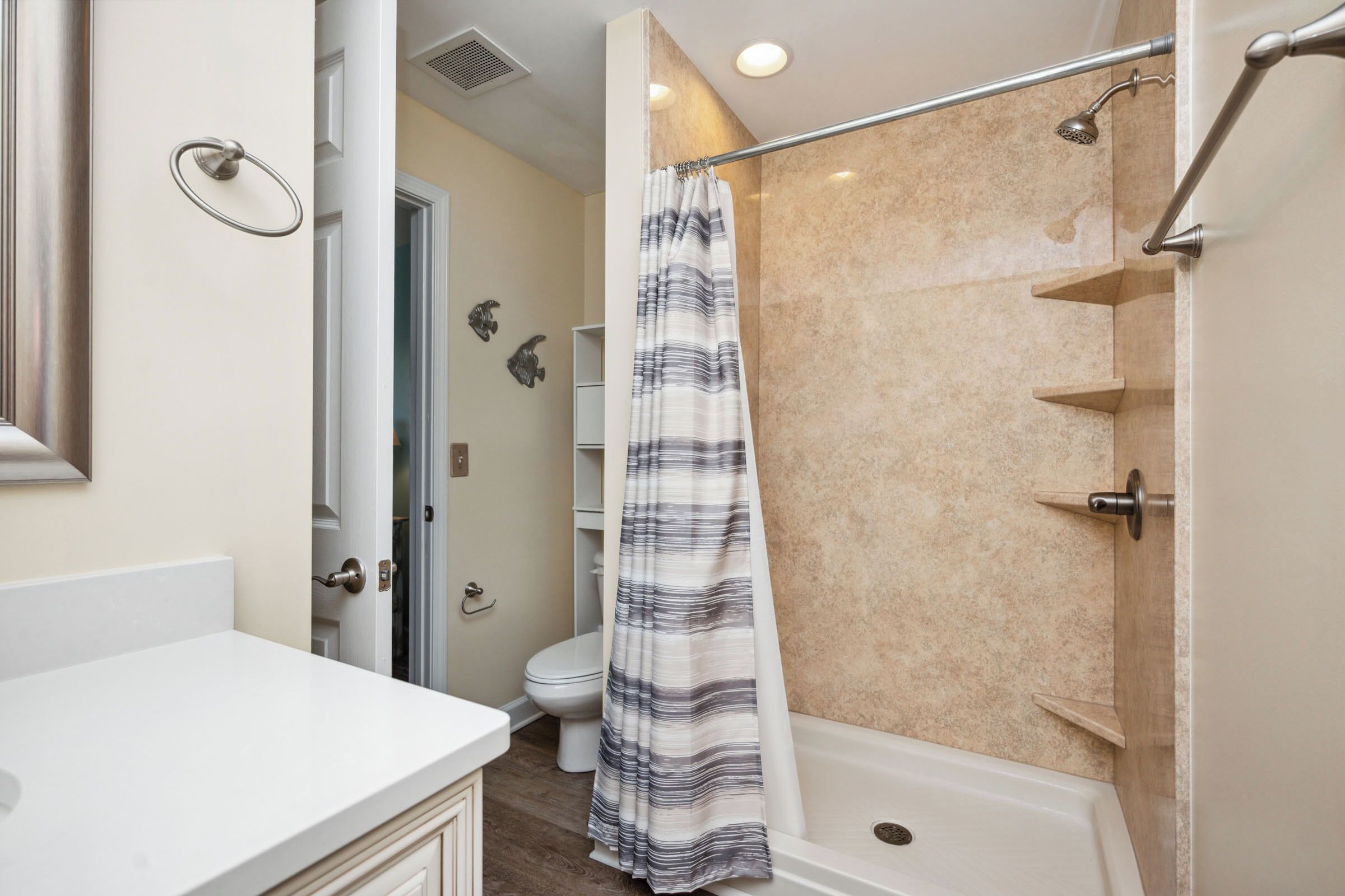 A bathroom with a shower, toilet, and sink.